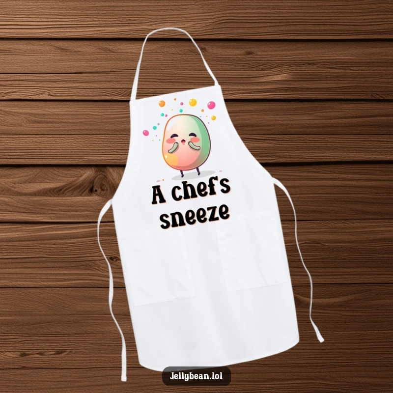 Funny apron depicting an anthropomorphic jelly bean sneezing a cloud of sugar dust, adding humor and sweetness to kitchen activities.